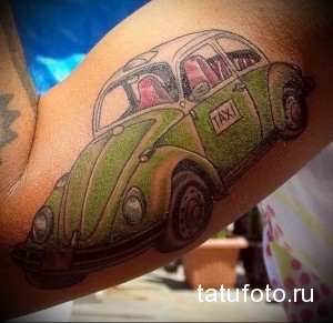 Фото тату с изображением зеленого Volkswagen Beetle в стиле мультфильма на предплечье. Яркий и оригинальный рисунок татуировки.