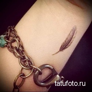 Фото маленькой татуировки пера на запястье. Тонкий и изящный рисунок, выполненный в технике лайнарт.