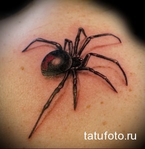 Фото реалистичной татуировки черного паука на коже. Рисунок выполнен с высокой детализацией, с прорисовкой всех элементов.