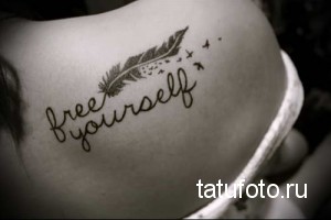 Фото тату на спине: небольшое перо и надпись 'free yourself' выполнены в технике лайнарт. Простой и вдохновляющий дизайн.