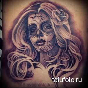 Фото тату на руке: девушка в стиле Sugar Skull с розой в волосах, выполненная в черно-белом стиле.