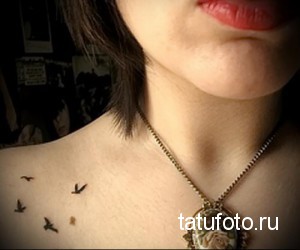 Фотография нескольких маленьких татуировок птиц, расположенных на шее девушки. Нежный и изящный рисунок татуировки.