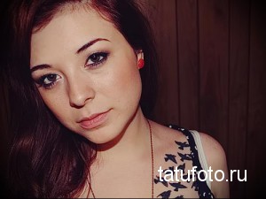 Фотография татуировки стаи черных птиц, летящих вдоль ключицы девушки. Минималистичный рисунок татуировки.