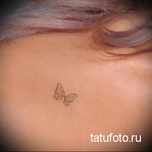 Фотография маленькой татуировки бабочки, выполненной тонкими линиями, на нежной коже шеи девушки. Изящный рисунок татуировки.