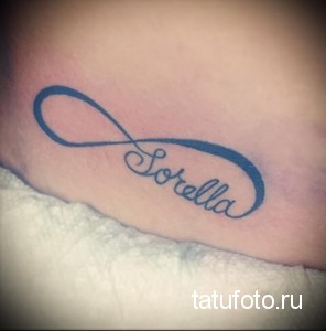 Фото тату: татуировка в виде знака бесконечности с надписью 'Sorella' (сестра) на запястье. Синий контурный рисунок.