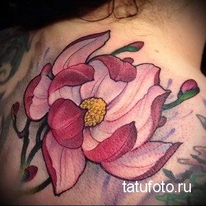 Фото тату розового лотоса на женской шее. Татуировка выполнена в мягких тонах с детальной проработкой лепестков и стебля.