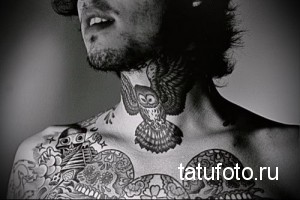 Фотография черно-белой татуировки совы и черепов на шее. Тату выполнено в графическом стиле с использованием тонких линий и узоров.
