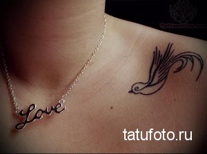 Фото тату ласточки и надписи 'Love' на женской ключице. Красивый, детализированный рисунок, выполненный в технике контурной татуировки. Идеально для тех, кто ищет идеи для романтичных татуировок.