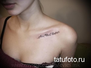 Фото тату надписи 'Amor Vincit Omnia' на женской ключице. Тонкая, изящная работа, выполненная черными чернилами. Идеально для тех, кто ищет идеи для небольших татуировок.