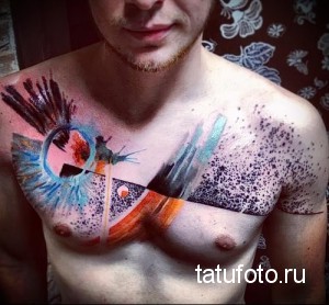 Фото тату на груди в стиле акварель. Абстрактный рисунок с использованием ярких цветов и размытых форм.
