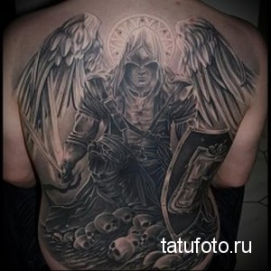 Фото тату ангела смерти на спине. Черно-белая татуировка, детализированные крылья, черепа, мрачная атмосфера, реалистичный стиль.