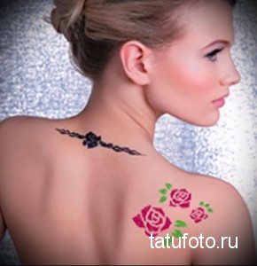 Фото тату хной с изображением розовых роз и черного узора на спине девушки. Декоративный рисунок, украшающий кожу, выполнен в нежных и контрастных тонах.
