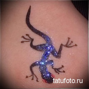 Фото тату хной с изображением синей ящерицы. Детализированный рисунок, имитирующий текстуру кожи и блеск чешуи, расположен на боку.