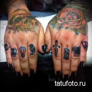 Фото тату на руках: множество маленьких цветных татуировок на пальцах, изображающих различные предметы и символы. Стиль олдскул.