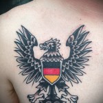 Фото тату орла с гербом Германии на груди. Черно-бело-красный рисунок, символизирующий патриотизм и национальную идентичность.