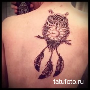 Фото тату совы с часами на спине. Черно-белая татуировка в стиле графика с детализированными перьями и шестеренками.