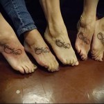 Фото парных татуировок в виде символа бесконечности с надписью 'Family Love' на стопах. Минималистичный дизайн, черные линии, символ семейной любви.