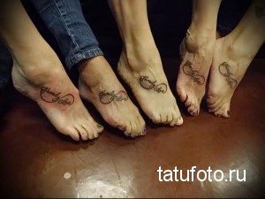 Фото парных татуировок в виде символа бесконечности с надписью 'Family Love' на стопах. Минималистичный дизайн, черные линии, символ семейной любви.
