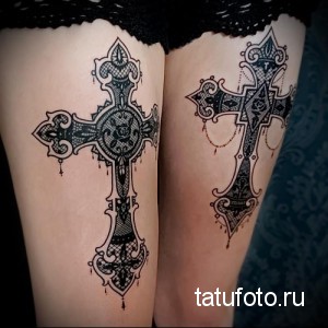 Фото двух изысканных татуировок кружевных крестов на бедрах. Черно-белый рисунок, выполненный в технике кружева.