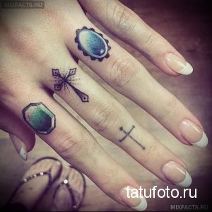 Фото нежных татуировок на пальцах: крест, два цветных камня и минималистичный крест. Деликатный рисунок.