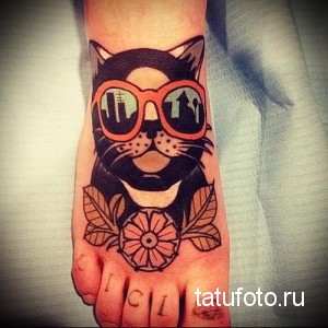 Фото тату кота в очках на стопе. Яркий и красочный рисунок в стиле олдскул.