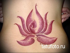 Фото тату: Изящный рисунок лотоса на боку, выполненный в технике dotwork, с использованием множества точек для создания объема и текстуры.