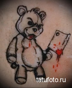 Фото татуировки с изображением злого медведя, держащего в лапе окровавленный нож. Рисунок выполнен в минималистичном стиле.