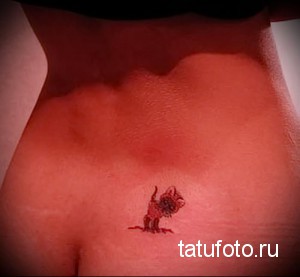 Фото татуировки маленькой бабочки на коже. Детализированный рисунок с использованием красных и черных оттенков.