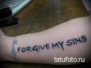 Фото тату надписи 'FORGIVE MY SINS' на предплечье, выполненной простым шрифтом черными чернилами.