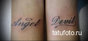 Фото тату с надписями 'Angel' и 'Devil' на запястьях, выполненные в черном цвете. Простые контуры, лаконичный дизайн.