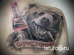 Фото тату медведя с бутылкой водки на плече. Реалистичный рисунок с детальной проработкой шерсти и агрессивным выражением морды.