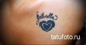 Фотография татуировки с именем 'Gabriella' и сердцем, расположенной на запястье. Рисунок выполнен черными чернилами.