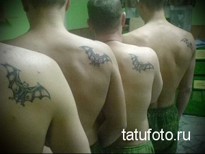Фото тату: три мужчины с татуировками летучих мышей на лопатках, демонстрирующие одинаковый дизайн.
