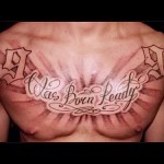 Фото тату с цифрами 1991 и надписью "Was Born Ready" на груди. Черно-серый рисунок с стилизованным шрифтом и лучами света.