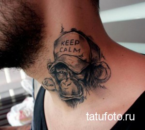 Фото тату обезьяны в кепке с надписью "Keep Calm". Черно-белая татуировка в реалистичном стиле, расположенная на шее.