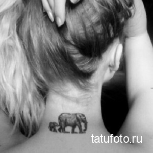 Фото тату слона и слоненка на затылке. Черно-белый рисунок татуировки, символизирующий материнство и семейные ценности. Изящный и минималистичный дизайн.