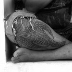 Фото тату слона, выполненного в стиле сакра геометрии с использованием черных линий и символов. Большая татуировка на ноге.