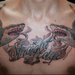 Фото тату на груди с изображением двух акул, парящих над надписью 'Straight Edge'.