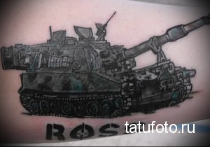 Фото тату на руке с изображением танка и надписью "ROSS". Черно-серый рисунок, реалистичный стиль.