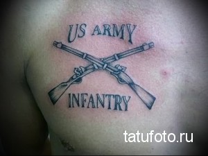 Фото тату с изображением перекрещенных винтовок и надписи 'US ARMY' и 'INFANTRY' на груди. Черно-серая татуировка в классическом стиле.
