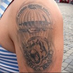 Фото тату на плече с изображением раскрытого парашюта и головы медведя, выполненное в черно-серых тонах. Подходит для мужчин, служивших в ВДВ.