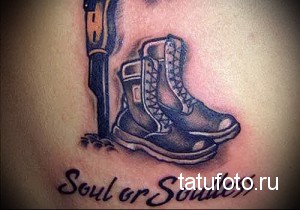 Фото тату на плече: ботинок, кинжал и надпись 'Soul or Soulless'. Черно-серый рисунок татуировки в реалистичном стиле.