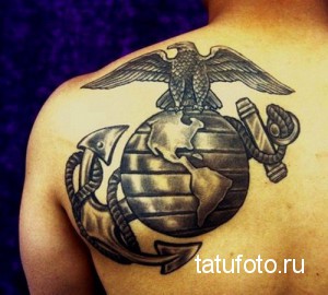Фото тату на спине: орел с американской символикой, держащий глобус. Черно-серый рисунок в стиле реализм.