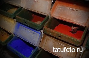 Фотография палитры красок для татуировок в небольших пластиковых контейнерах. Видны различные цвета: желтый, зеленый, синий, красный и другие.