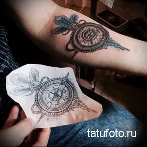 Фото тату компаса с розами на руке, выполненное в технике лайнуорк с добавлением акварельных оттенков. Детализированный рисунок с эскизом.