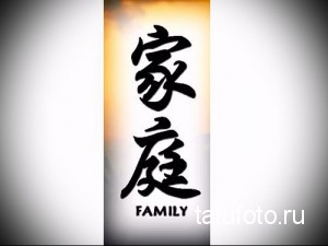 Фото тату с двумя черными иероглифами, символизирующими семью, и надписью 'FAMILY'. Татуировка выполнена в вертикальном формате.