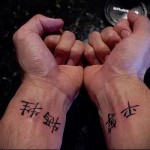 Фото парных тату на запястьях: черные иероглифы, символизирующие любовь и верность. Идеально для пар, желающих выразить свои чувства.