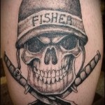 Фото тату черепа в военной каске с надписью 'FISHER' и перекрещенными кинжалами на руке. Черно-серая татуировка в реалистичном стиле.