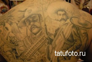 Большая татуировка на спине мужчины, изображающая портреты мексиканских революционеров, таких как Панчо Вилья и Эмилиано Сапата. Татуировка выполнена в реалистичном стиле.