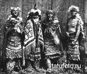 Фотография группы африканских мужчин с традиционными татуировками на теле, одетых в ритуальные одежды.